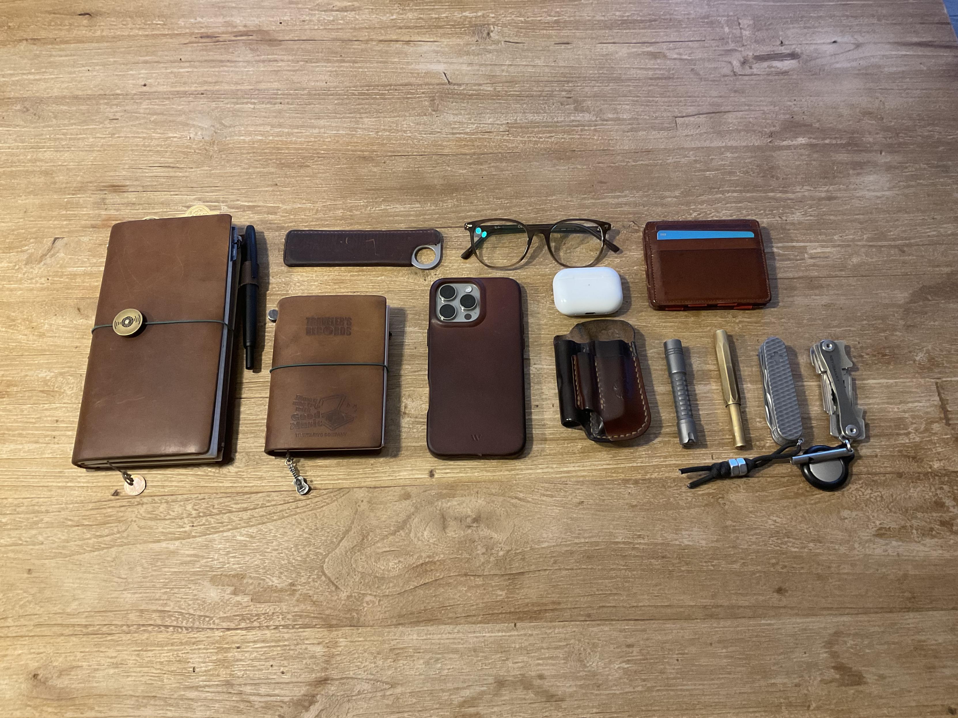 Mein komplettes EDC bestehend aus Notizbüchern, iPhone im Ledervsse, Brille, Portemonnaie, Airpods Pro, Lederorganizer, Taschenlampe, Füllern, SAK, Keybar und Kamm